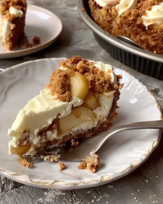 Slice of apple crumble cheesecake with a crunchy topping and crumbled apples