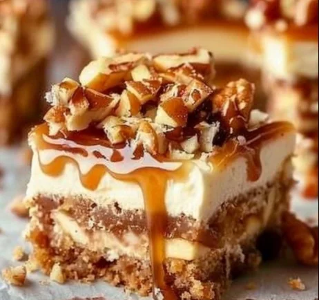 Delicious Caramel Apple Cheesecake Bars topped with caramel drizzle and apple slices.