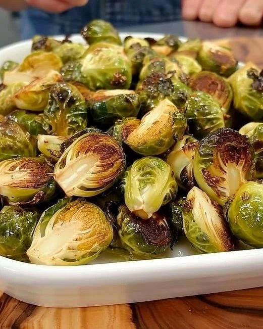 Crispy Brussels Sprouts with Tangy-Sweet Dressing 2 Crispy Brussels sprouts topped with tangy-sweet dressing on a plate.