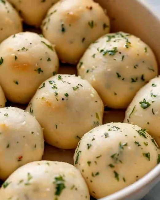 Garlic Bread Rolls 2 Freshly baked Garlic Bread Rolls with herbs and butter on a wooden board.