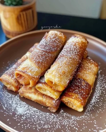 Delicious rolled French toasts filled with sweet ingredients and served on a plate.