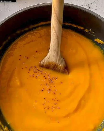 Bowl of creamy sweet potato soup garnished with herbs and spices