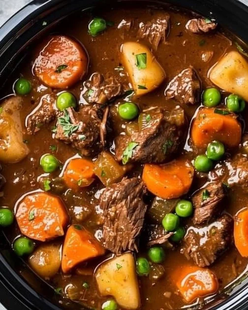 Comforting Crockpot Beef Stew 2 Delicious comforting crockpot beef stew in a bowl garnished with fresh herbs.
