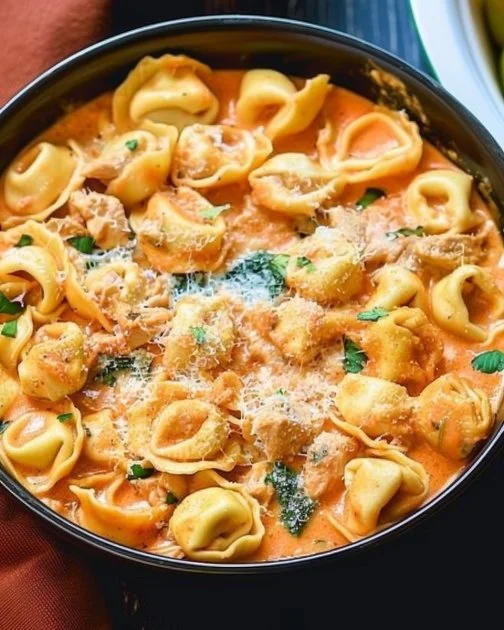 Bowl of CrockPot Chicken Tortellini garnished with herbs