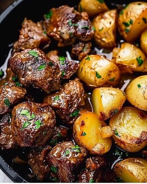 Garlic Butter Beef Bites with Potatoes 2 Plate of garlic butter beef bites with potatoes, garnished and ready to serve