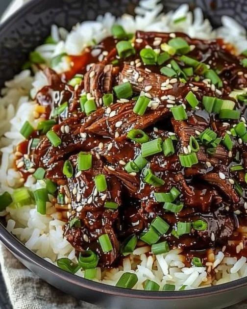 Slow Cooker Korean Beef 2 Delicious slow cooker Korean beef dish garnished with green onions and sesame seeds.